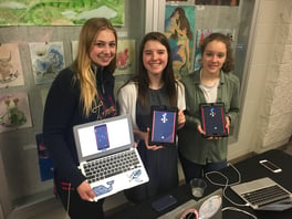 Three girls holding computers