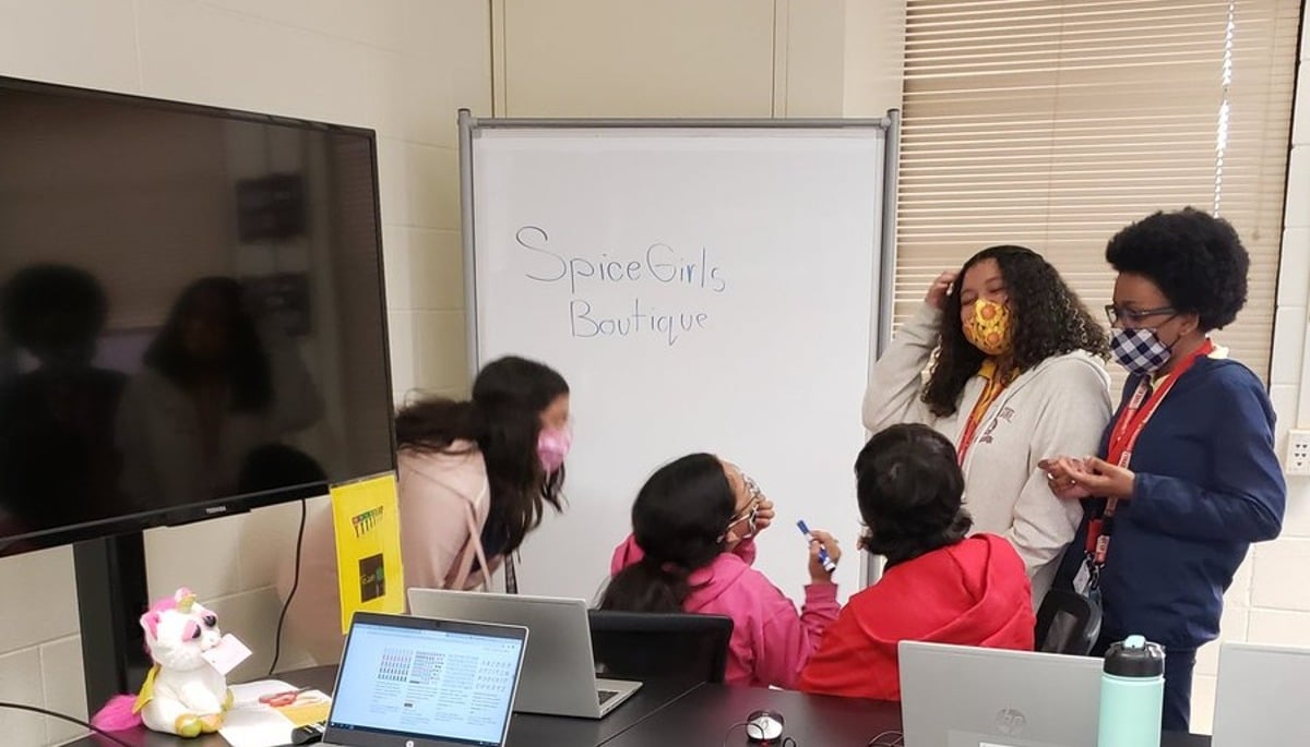 students engaged around a laptop